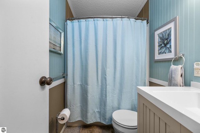 bathroom with a shower with curtain, sink, a textured ceiling, and toilet