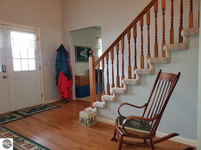 entryway with stairs, baseboards, and wood finished floors