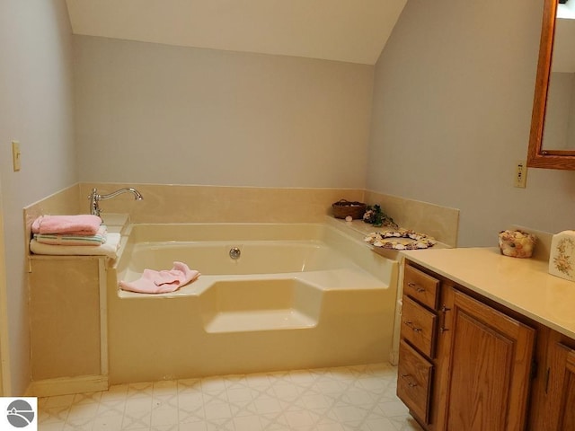 full bath with lofted ceiling, a garden tub, vanity, and tile patterned floors