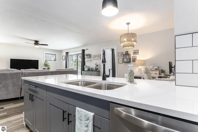 kitchen with gray cabinets, pendant lighting, dishwasher, sink, and light hardwood / wood-style floors