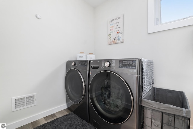 laundry room featuring hardwood / wood-style flooring and washer and dryer