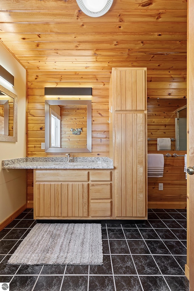 bathroom featuring vanity, tile patterned flooring, and wooden walls