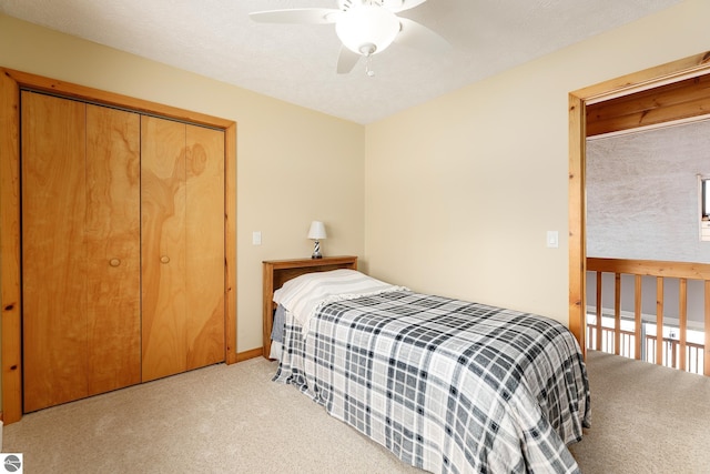 bedroom with light carpet, ceiling fan, and a closet