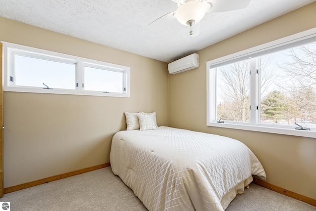 bedroom featuring light carpet, an AC wall unit, and a textured ceiling