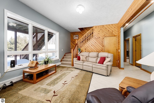 living room featuring light tile patterned flooring, a textured ceiling, and wood walls