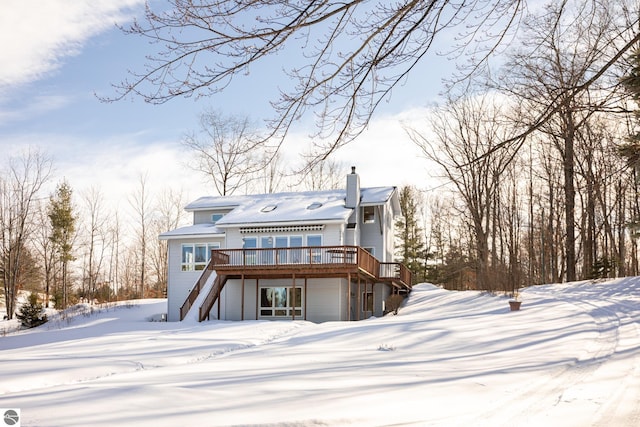 snow covered property with a wooden deck