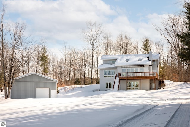 view of front of home with a garage, a wooden deck, and an outdoor structure