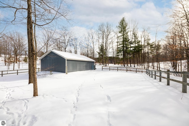 yard covered in snow with an outbuilding