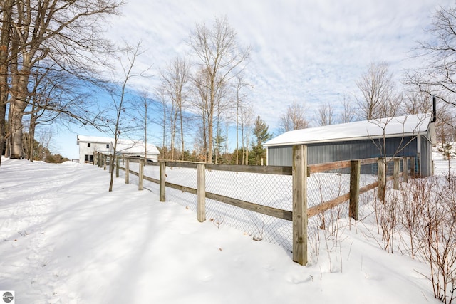 yard layered in snow with an outdoor structure