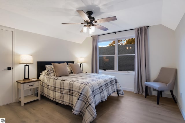 bedroom with baseboards, lofted ceiling, wood finished floors, and a ceiling fan