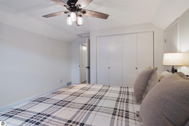 bedroom featuring visible vents, a ceiling fan, a closet, baseboards, and vaulted ceiling