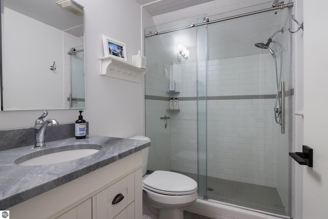 bathroom featuring vanity, toilet, and walk in shower