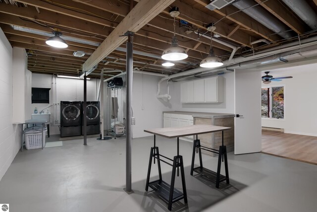 below grade area with washer and dryer, a baseboard heating unit, and a sink