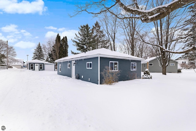 view of snowy exterior with an outbuilding