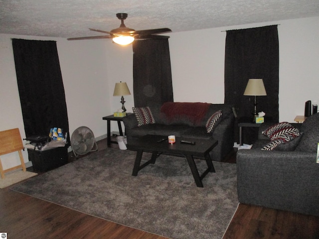 living room featuring wood-type flooring, ceiling fan, and a textured ceiling