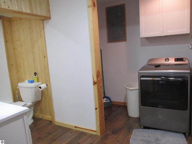 clothes washing area featuring dark hardwood / wood-style flooring, washer / dryer, electric panel, and cabinets