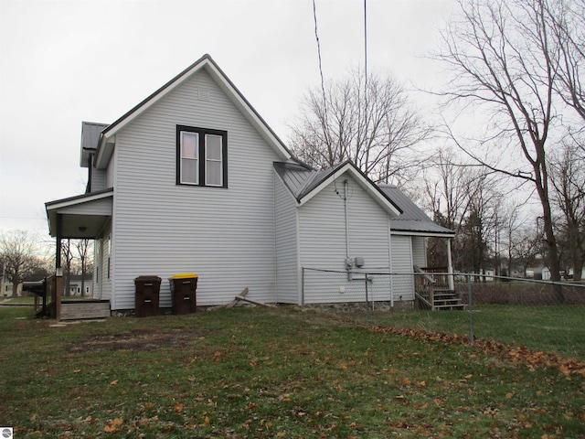 rear view of property featuring a yard and a porch