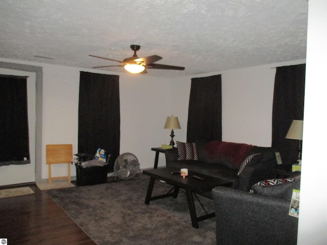 living room with ceiling fan, wood-type flooring, and a textured ceiling