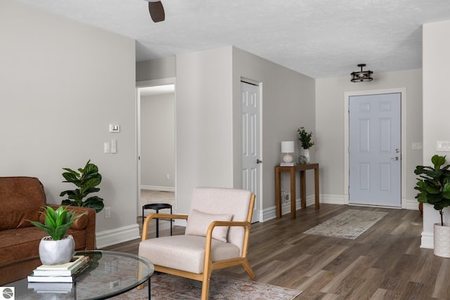 foyer with dark wood-style floors, a textured ceiling, and baseboards