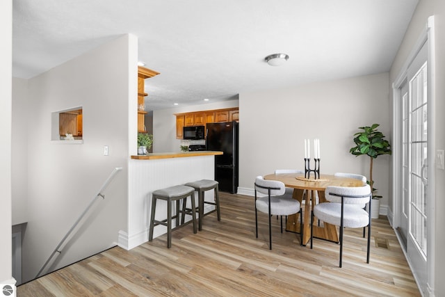 dining area featuring recessed lighting, light wood-style floors, and baseboards