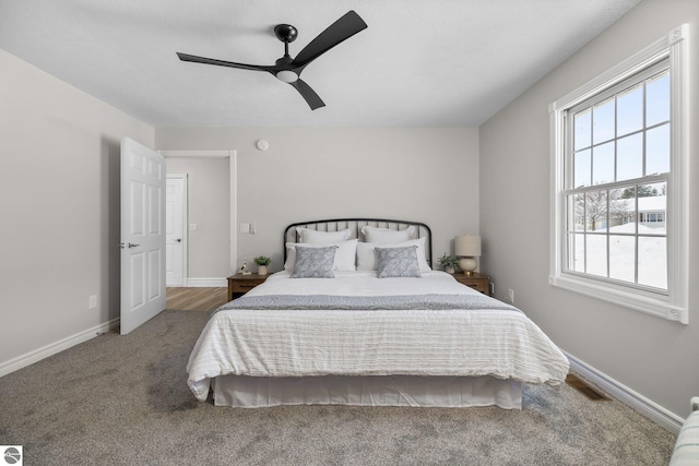 carpeted bedroom with visible vents, baseboards, and ceiling fan