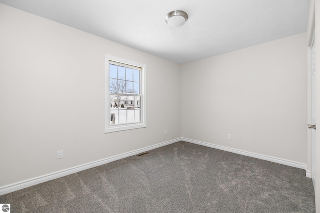 empty room with baseboards and dark carpet