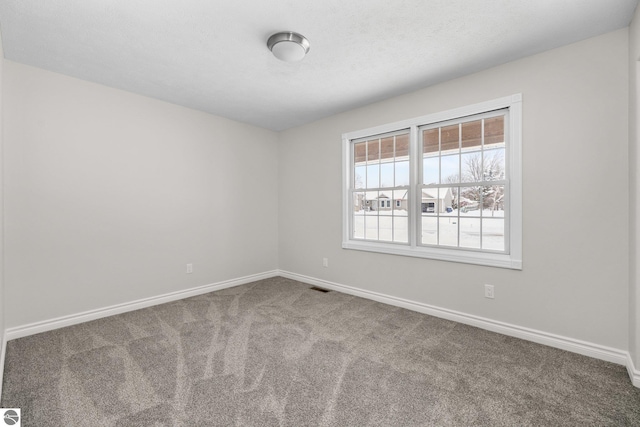 empty room featuring visible vents, baseboards, and carpet flooring