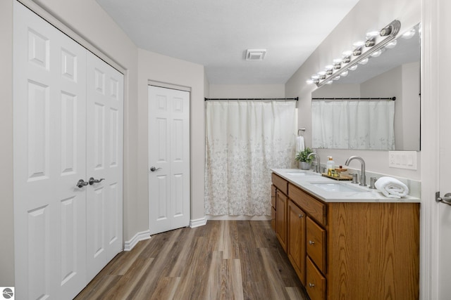 full bath with vanity, wood finished floors, and visible vents