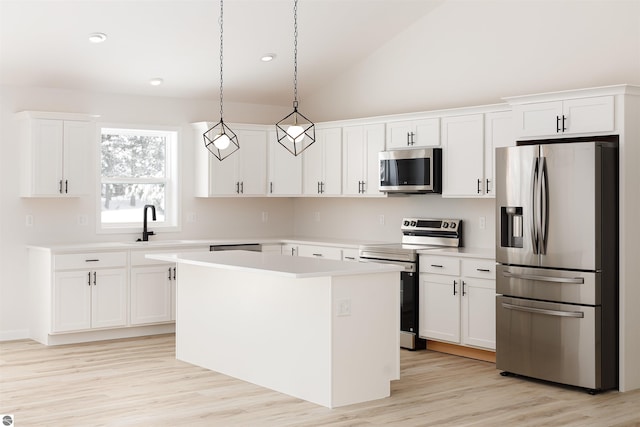 kitchen featuring hanging light fixtures, white cabinetry, appliances with stainless steel finishes, and a center island