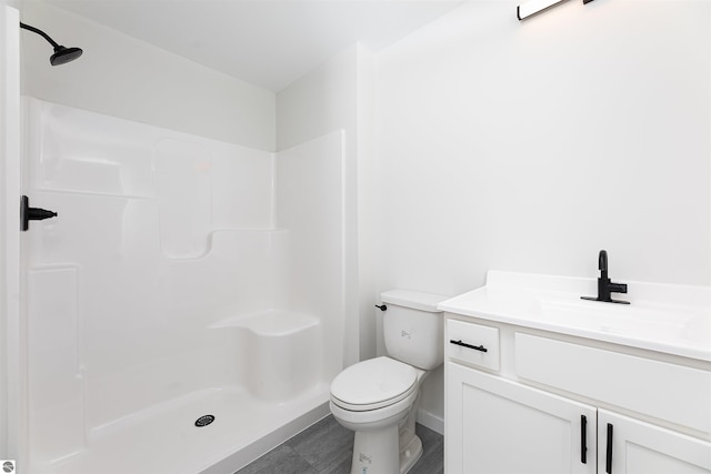 bathroom featuring vanity, toilet, and walk in shower