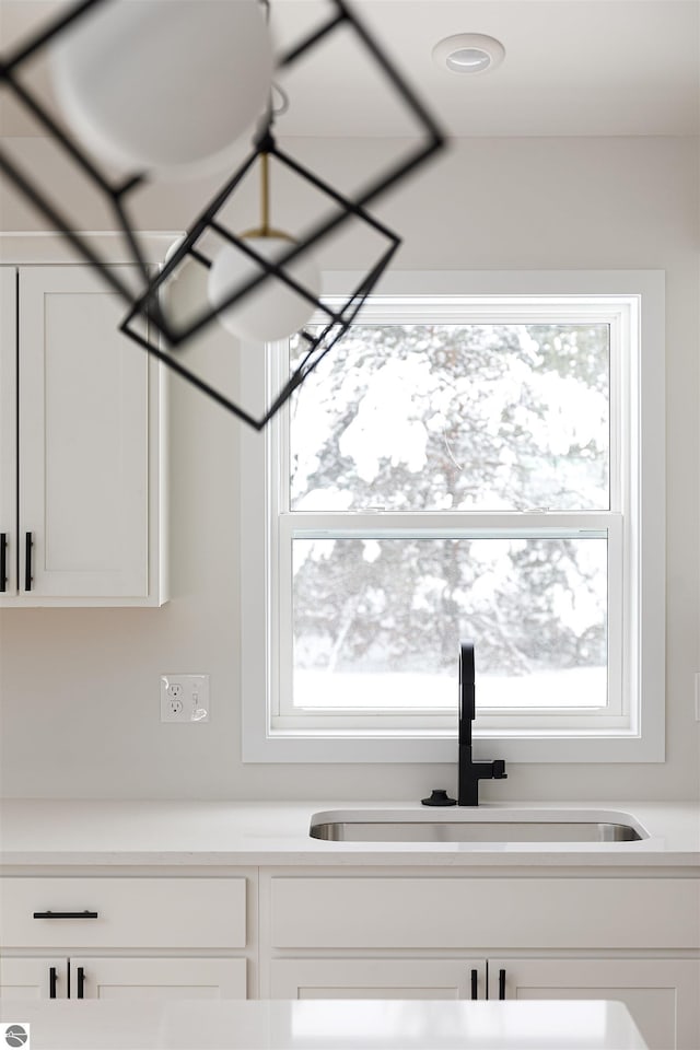 interior space featuring white cabinetry and sink