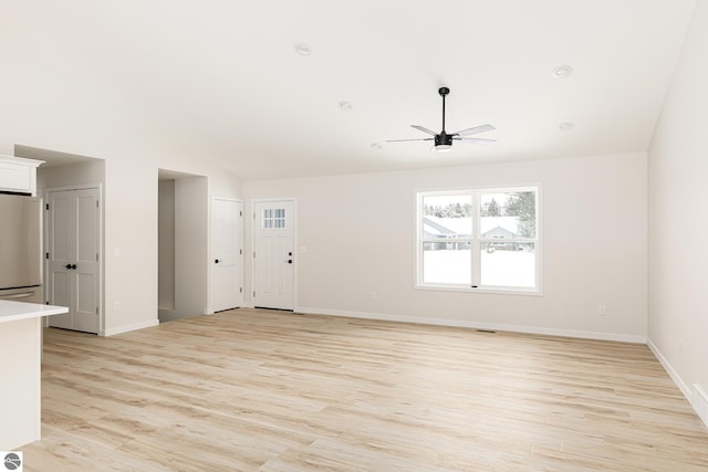 unfurnished living room featuring vaulted ceiling, ceiling fan, and light wood-type flooring