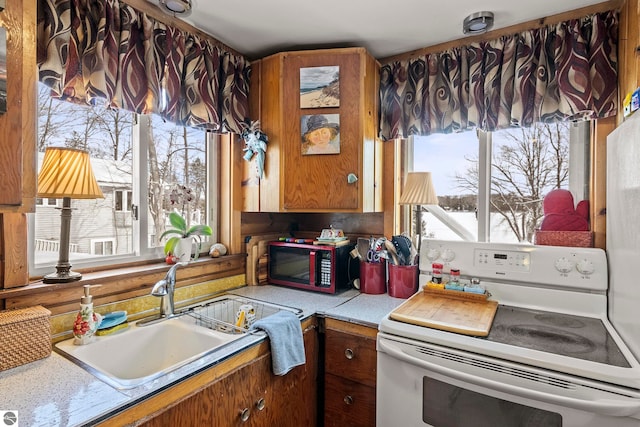 kitchen with sink, plenty of natural light, and white electric stove