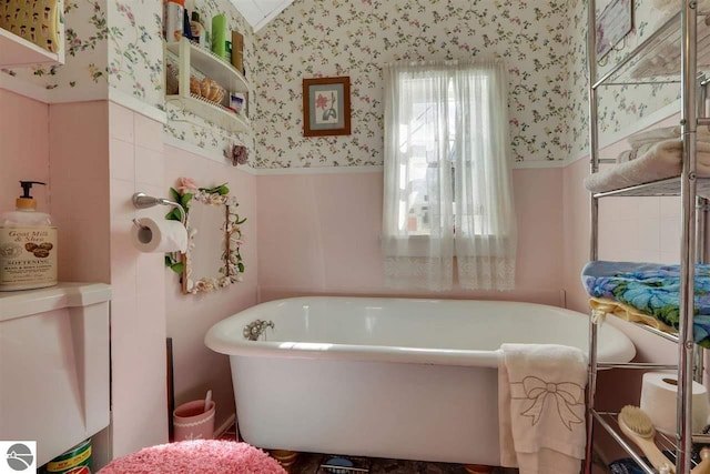 bathroom with vaulted ceiling and a tub