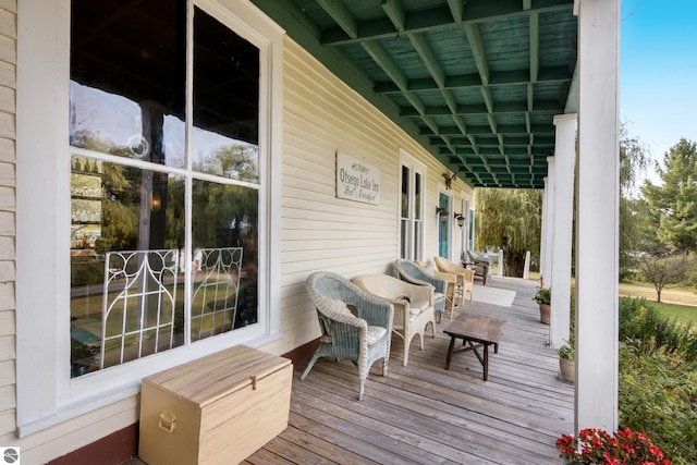 wooden terrace featuring area for grilling and a porch