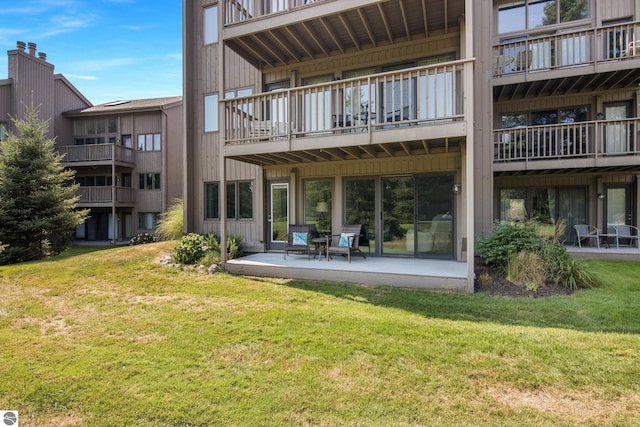 rear view of property with a yard and a patio area