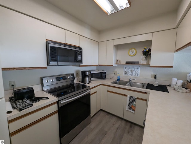 kitchen with white cabinetry, appliances with stainless steel finishes, sink, and light wood-type flooring