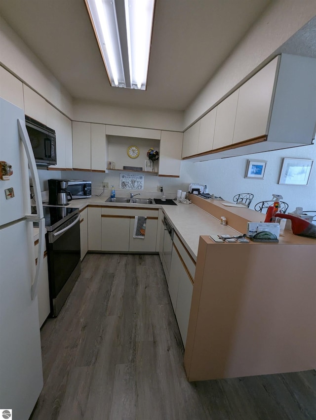 kitchen with white cabinetry, hardwood / wood-style floors, and appliances with stainless steel finishes