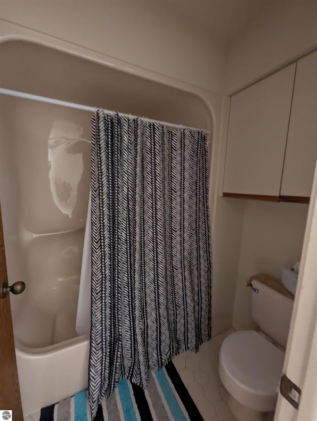 bathroom featuring shower / bathtub combination with curtain and toilet