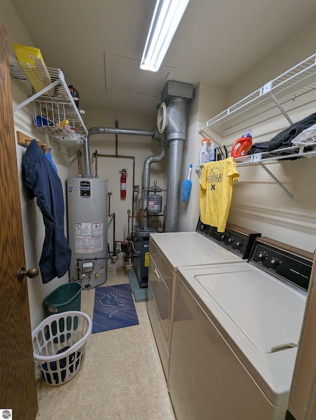 clothes washing area featuring water heater and separate washer and dryer