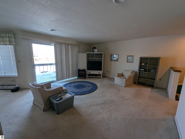 living room featuring baseboard heating, carpet, and a textured ceiling