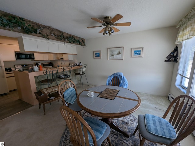 carpeted dining area featuring ceiling fan, a textured ceiling, and a baseboard heating unit