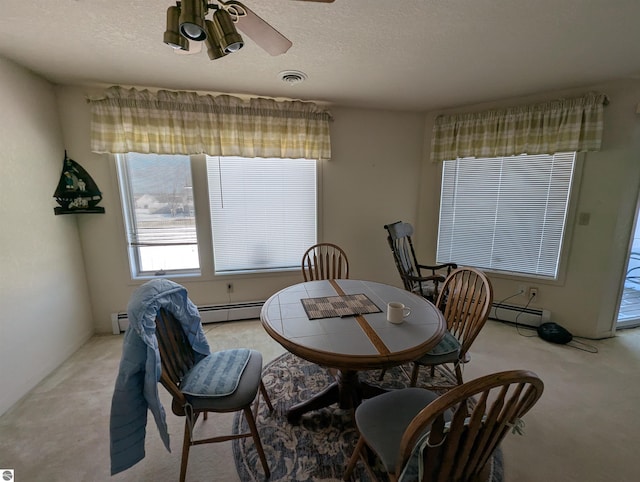 dining space with a baseboard radiator, light colored carpet, a textured ceiling, and ceiling fan