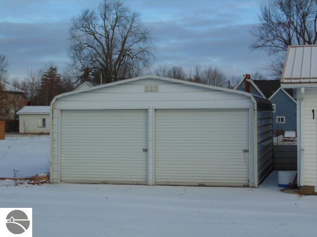 snow covered garage with a detached garage