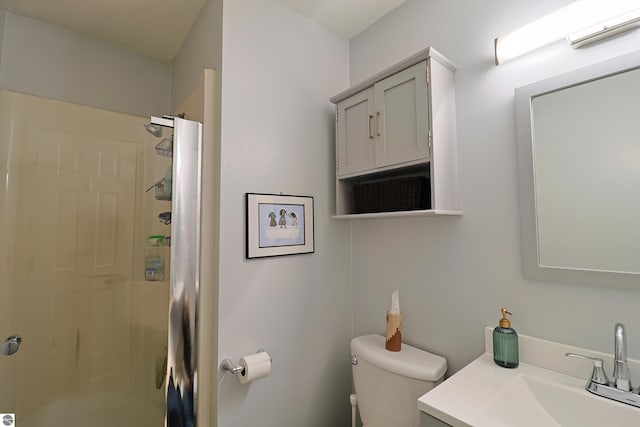 bathroom with walk in shower, vanity, and toilet