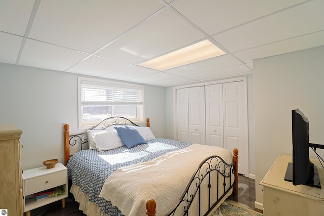 bedroom featuring a paneled ceiling and a closet