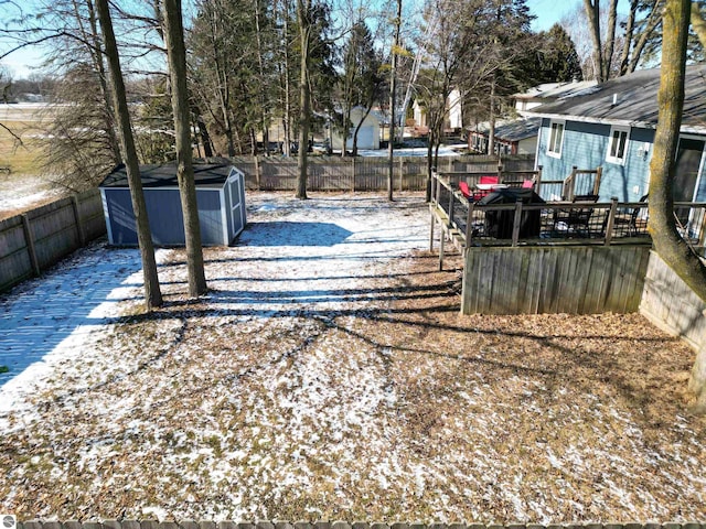 yard layered in snow with a storage unit