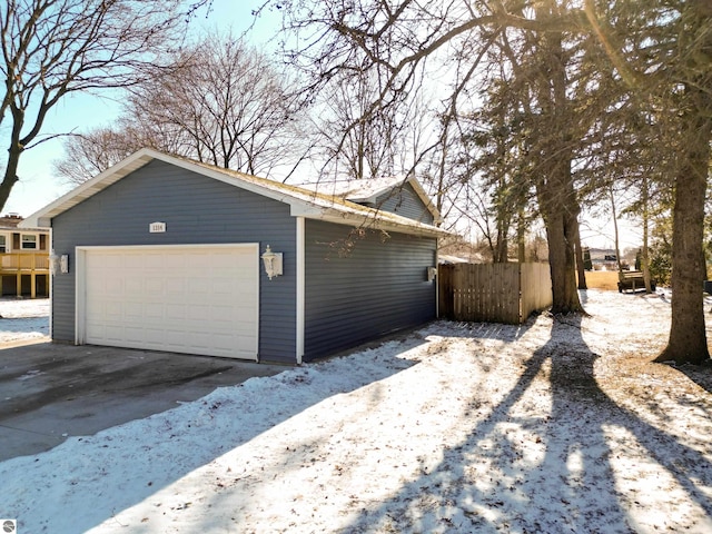 view of snow covered exterior with an outbuilding and a garage