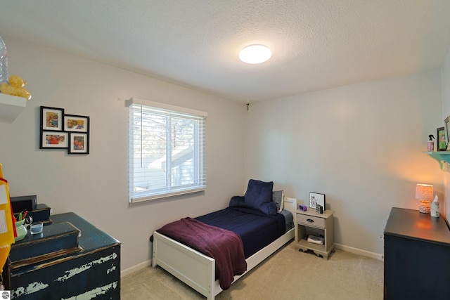 bedroom featuring light carpet and a textured ceiling