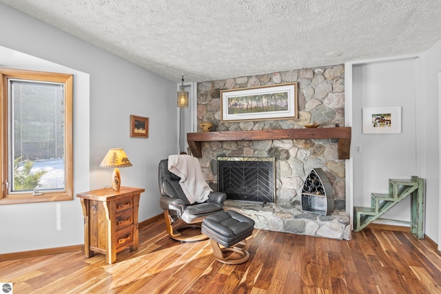 living area featuring a fireplace, hardwood / wood-style floors, and a textured ceiling